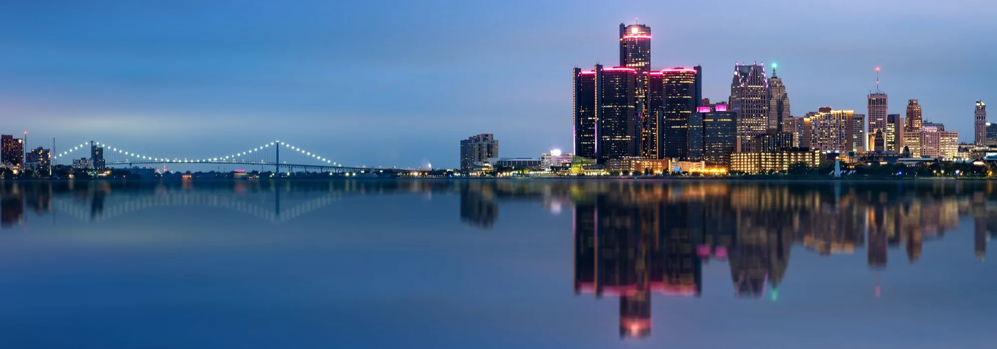 The Detroit skyline and Ambassador Bridge seen at dusk from the Windsor side of the river