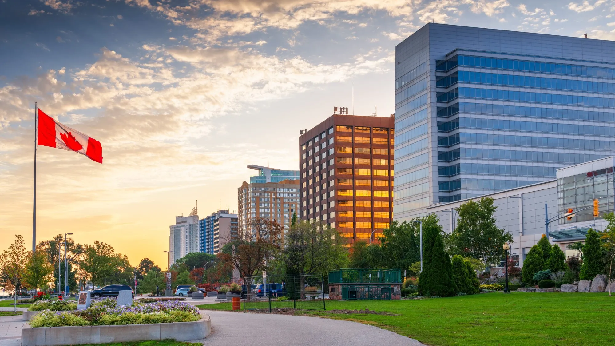 Windsor's riverfront park and downtown towers at sunset, Canadian flag flying